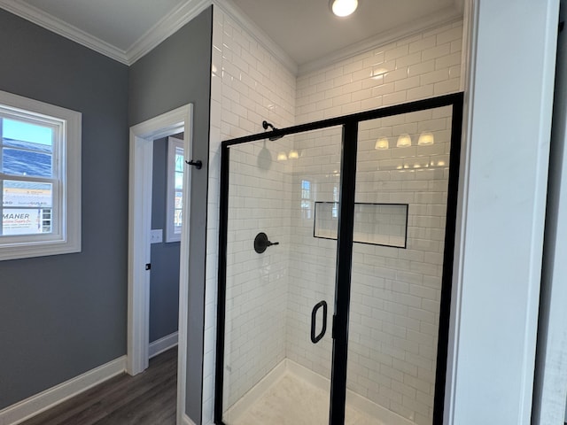 bathroom with a stall shower, a healthy amount of sunlight, crown molding, and baseboards