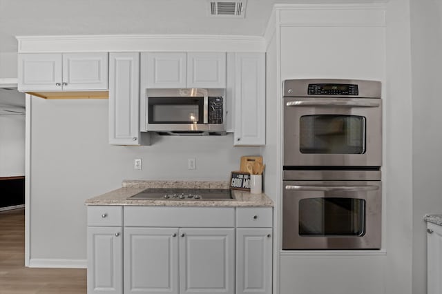 4221 Cap Chat St, Hephzibah, GA 30815 - kitchen featuring stainless steel appliances, light wood-style flooring, white cabinetry, and light stone countertops