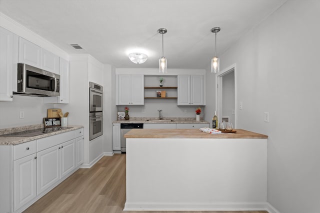 4221 Cap Chat St, Hephzibah, GA 30815 - kitchen with appliances with stainless steel finishes, open shelves, light wood-style flooring, white cabinets, and decorative light fixtures