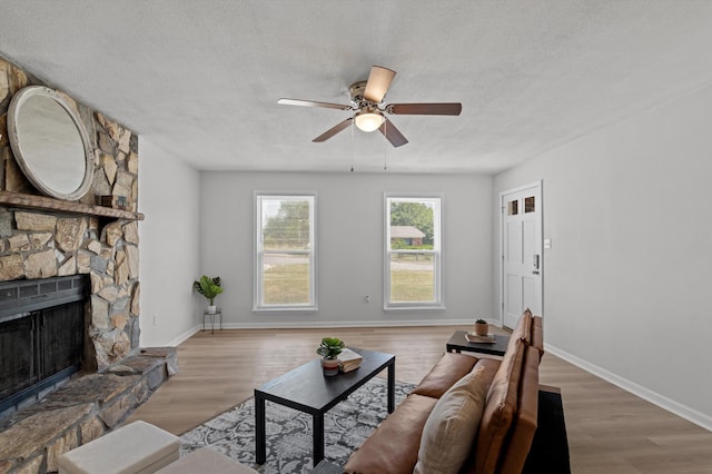 4221 Cap Chat St, Hephzibah, GA 30815 - living area with a ceiling fan, a textured ceiling, wood finished floors, and a stone fireplace