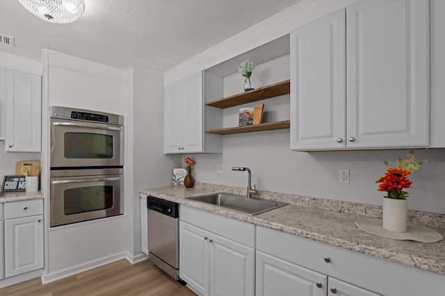 4221 Cap Chat St, Hephzibah, GA 30815 - kitchen featuring stainless steel appliances, open shelves, light wood-style flooring, white cabinets, and a textured ceiling