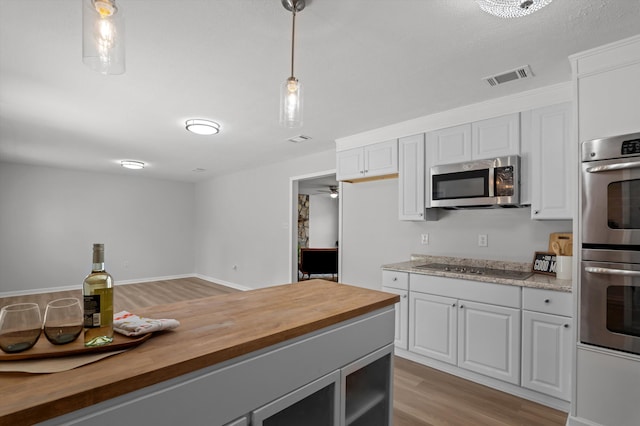 4221 Cap Chat St, Hephzibah, GA 30815 - kitchen with butcher block counters, stainless steel appliances, light wood finished floors, and decorative light fixtures