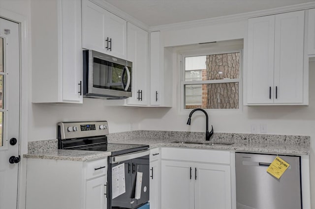 kitchen with sink, white cabinetry, stainless steel appliances, and ornamental molding