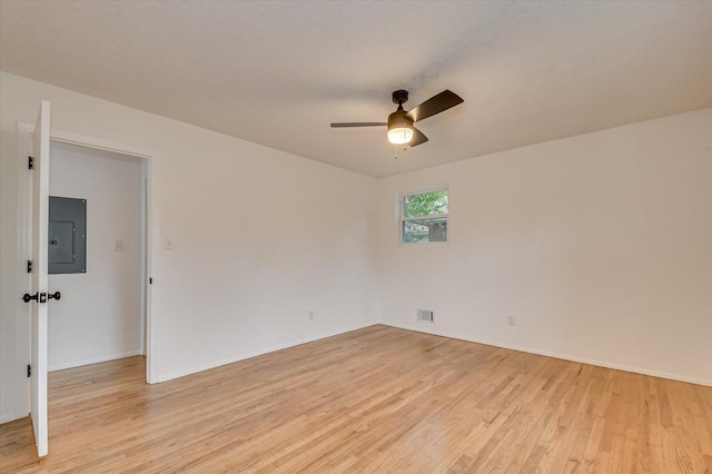 spare room featuring electric panel, ceiling fan, and light hardwood / wood-style floors