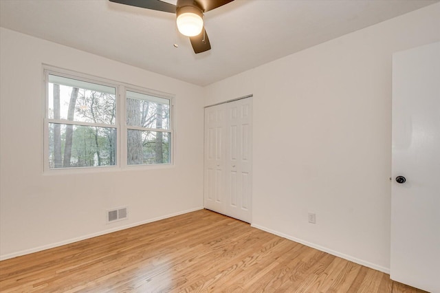 empty room with ceiling fan and light hardwood / wood-style floors