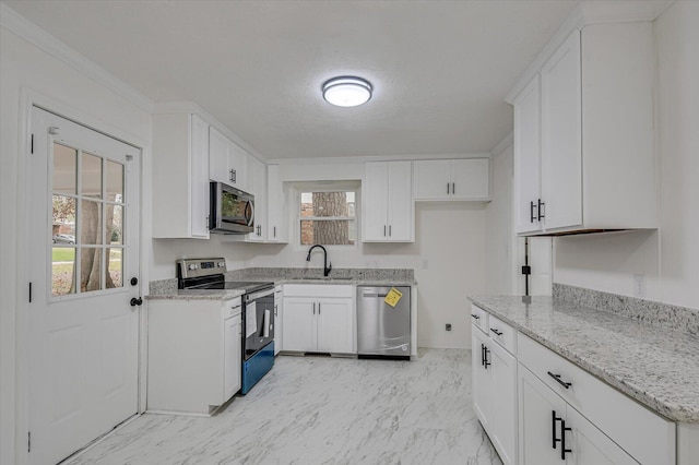 kitchen with light stone counters, sink, white cabinetry, and stainless steel appliances