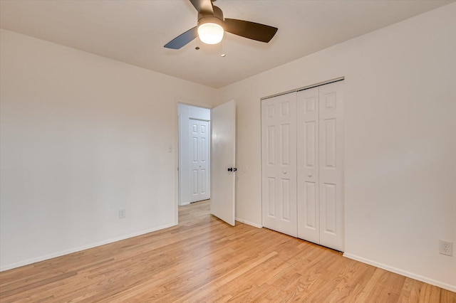 unfurnished bedroom with ceiling fan, light wood-type flooring, and a closet