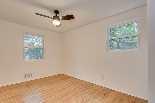 empty room with light hardwood / wood-style floors, ceiling fan, and a healthy amount of sunlight