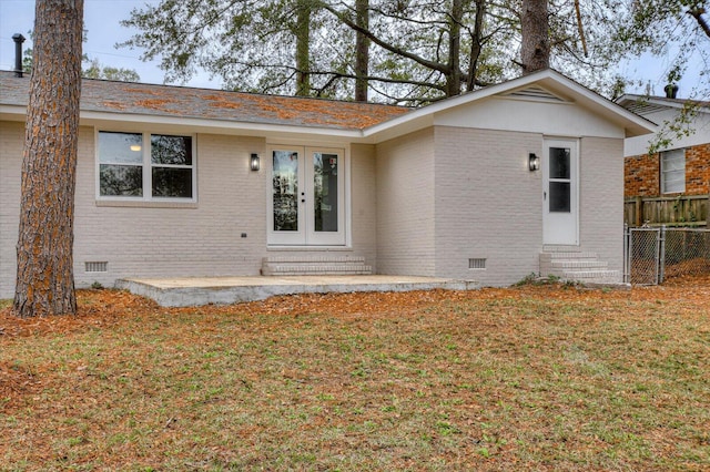 view of front facade with a front yard and french doors