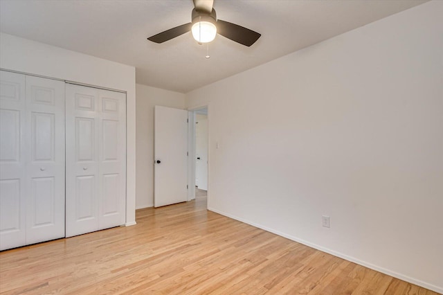 unfurnished bedroom featuring light wood-type flooring, a closet, and ceiling fan