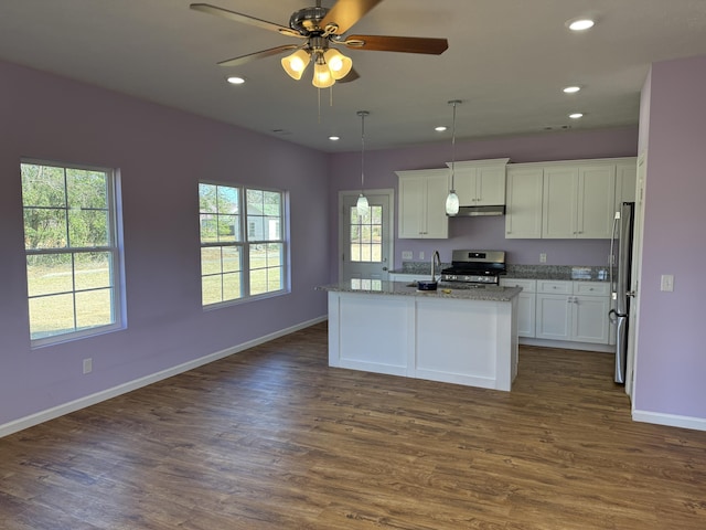 kitchen with white cabinetry, a kitchen island with sink, hanging light fixtures, stainless steel appliances, and light stone counters