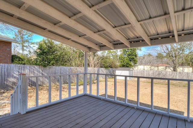 wooden deck featuring a storage shed, a lawn, an outdoor structure, and a fenced backyard