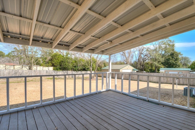 deck featuring a fenced backyard, cooling unit, and an outdoor structure