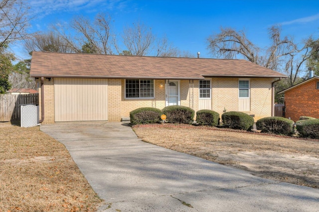 ranch-style house featuring driveway, fence, and brick siding