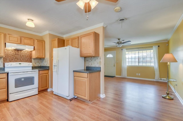 kitchen with white appliances, dark countertops, light wood-style flooring, crown molding, and under cabinet range hood