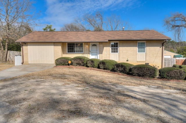 single story home with driveway, a garage, fence, and brick siding