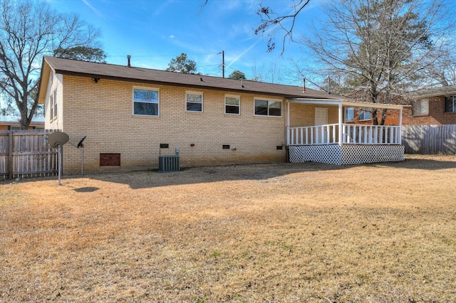 rear view of house with crawl space, fence, and brick siding