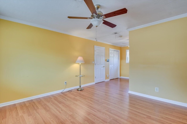 spare room featuring baseboards, crown molding, and light wood finished floors