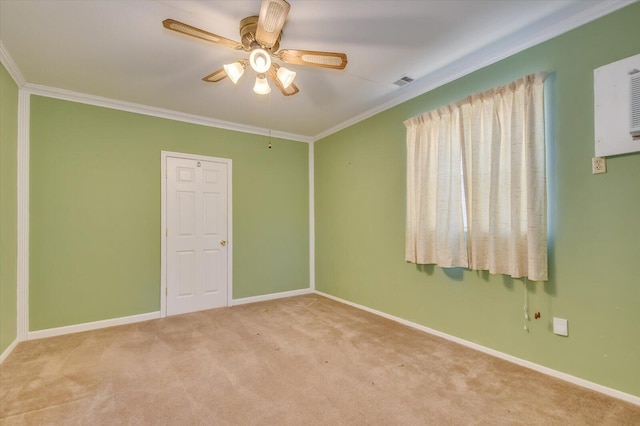 carpeted spare room with baseboards, visible vents, a ceiling fan, and crown molding