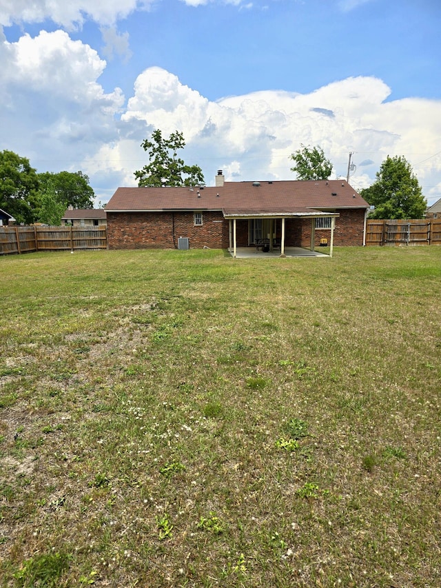 3807 Fairington Dr, Hephzibah, GA 30815 - rear view of property featuring a fenced backyard, a chimney, brick siding, a patio area, and a yard