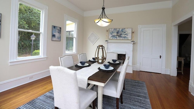 dining space featuring a brick fireplace and dark hardwood / wood-style flooring