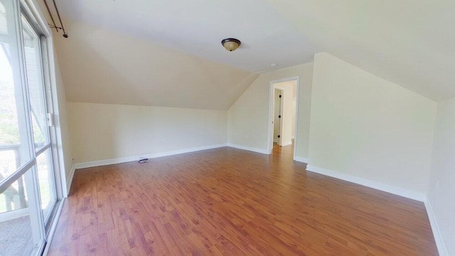 bonus room with hardwood / wood-style flooring, vaulted ceiling, and a wealth of natural light