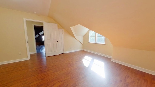 bonus room with hardwood / wood-style floors and vaulted ceiling