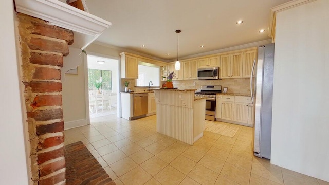 kitchen with pendant lighting, sink, stainless steel appliances, a kitchen island, and decorative backsplash