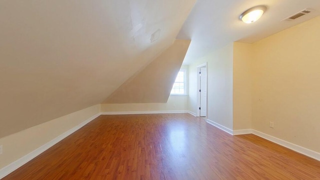 bonus room with vaulted ceiling and light hardwood / wood-style floors