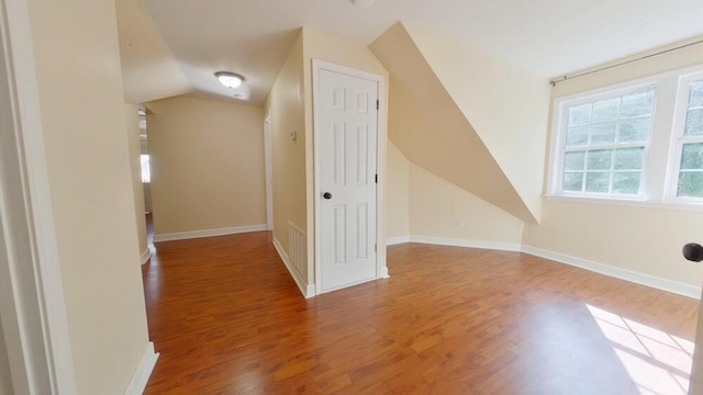 additional living space with lofted ceiling and hardwood / wood-style floors