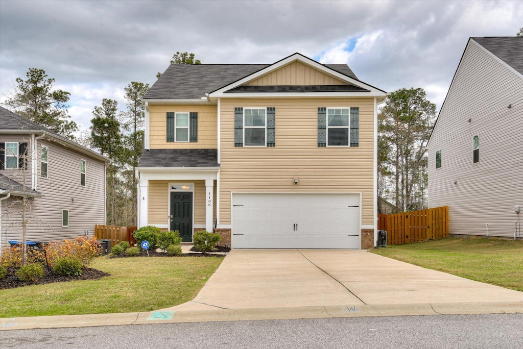 craftsman house featuring a garage and a front lawn