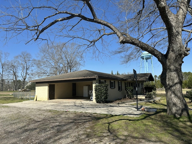 view of property exterior with a yard, driveway, and an attached carport