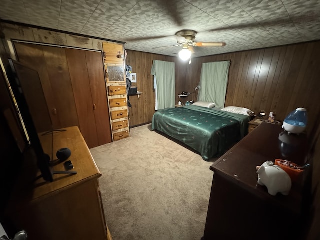 bedroom featuring carpet floors, ceiling fan, and wood walls