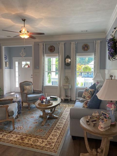256 Candlewick Loop, Mccormick, SC 29835 - living room with wood finished floors, a decorative wall, a wainscoted wall, a ceiling fan, and ornamental molding