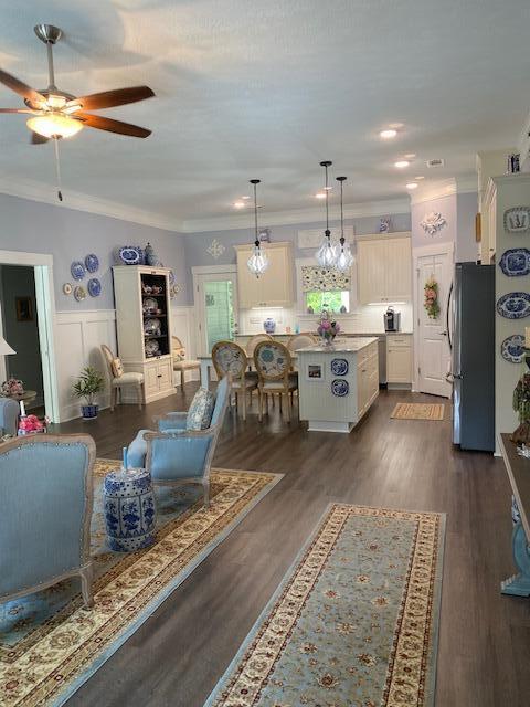 256 Candlewick Loop, Mccormick, SC 29835 - living room featuring ornamental molding, ceiling fan, wainscoting, and dark wood-style floors