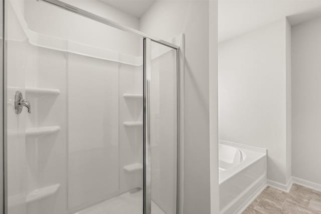 bathroom featuring separate shower and tub