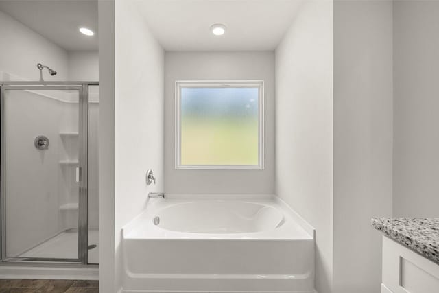 bathroom with vanity and shower with separate bathtub