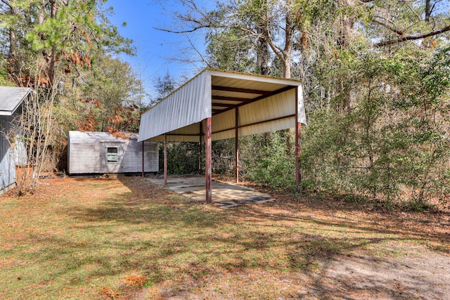 view of yard featuring a carport, an outbuilding, and a shed