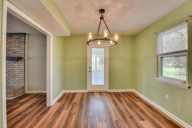 interior space featuring baseboards, a chandelier, and wood finished floors