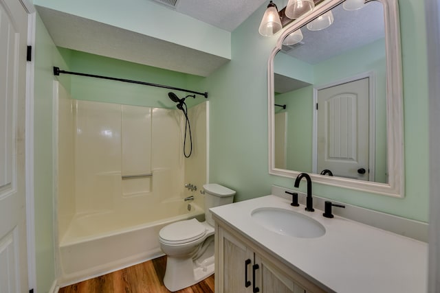 full bath with a textured ceiling, bathtub / shower combination, toilet, wood finished floors, and vanity