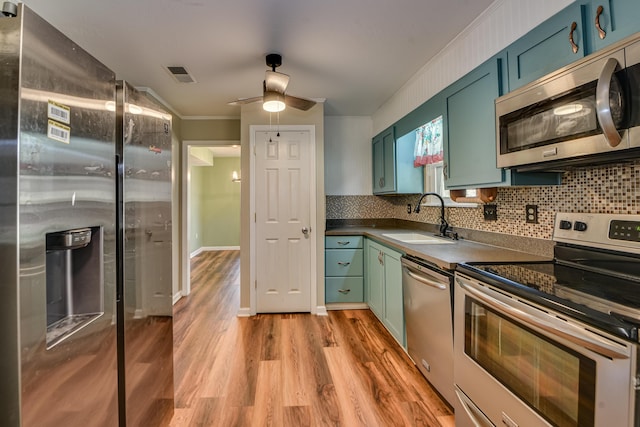 kitchen featuring visible vents, dark countertops, appliances with stainless steel finishes, a sink, and green cabinetry