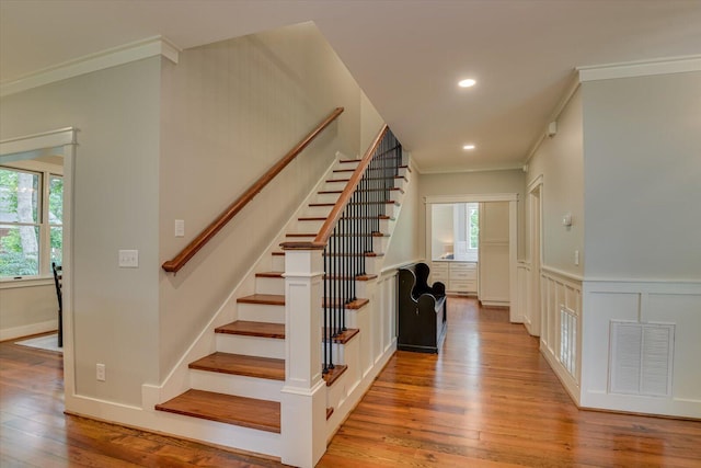 stairs featuring hardwood / wood-style floors and crown molding