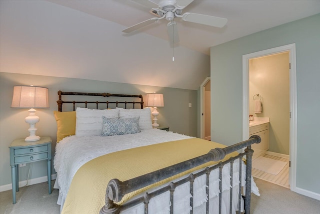 carpeted bedroom with ceiling fan, lofted ceiling, and ensuite bathroom