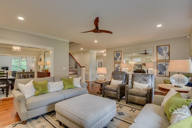 living room featuring light hardwood / wood-style floors, ceiling fan, and ornamental molding