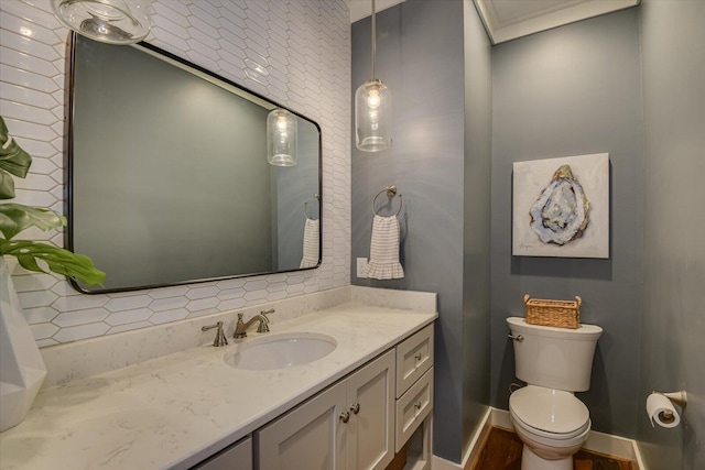 bathroom with crown molding, vanity, and toilet