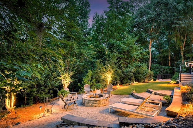 patio terrace at dusk with a yard and an outdoor fire pit