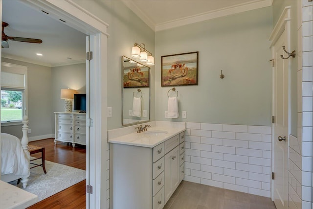 bathroom featuring ceiling fan, hardwood / wood-style flooring, vanity, and ornamental molding