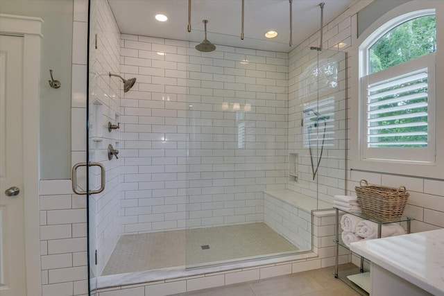 bathroom featuring tile patterned floors, plenty of natural light, and a shower with shower door