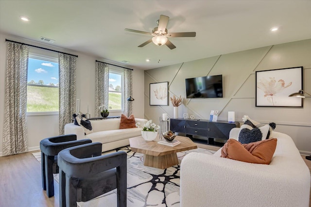 living room with light wood-type flooring and ceiling fan