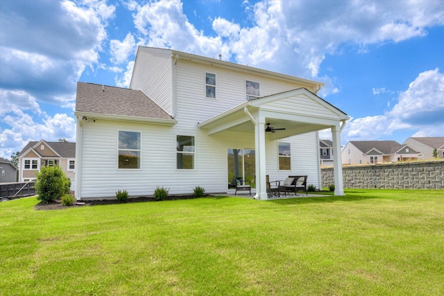 rear view of house featuring a yard, ceiling fan, and a patio area